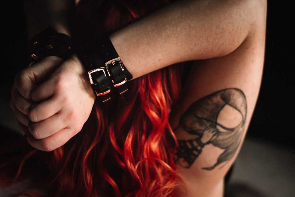 boudoir session with woman with red hair in handcuffs
