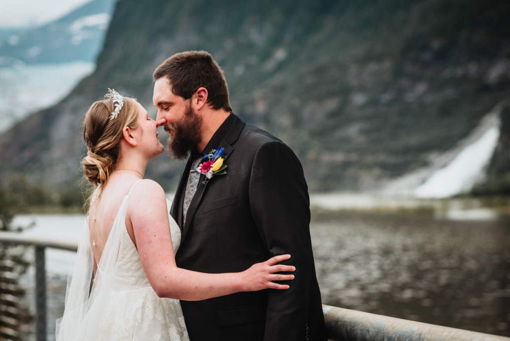 bride and groom near the nugget falls waterfall in juneau alaska