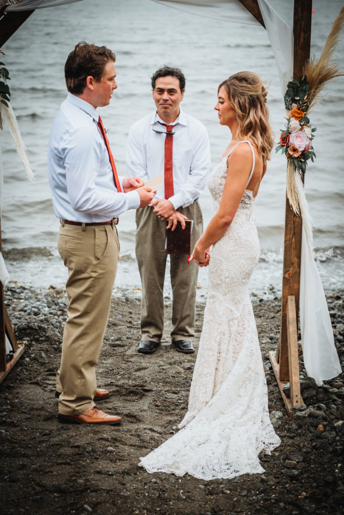 reading vows during a rocky beach elopement in juneau alaska