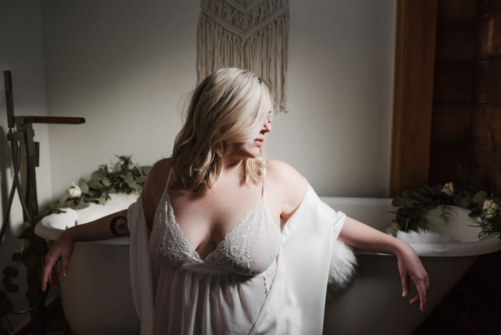 woman in white boudoir bathtub session