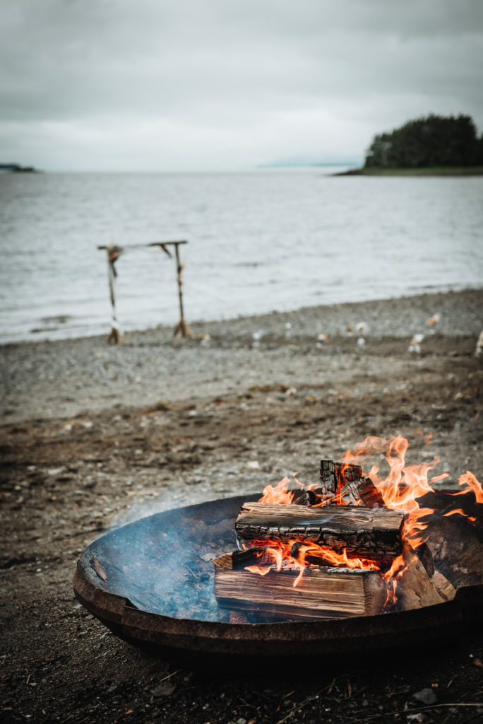 open firepit on the beach near the arch