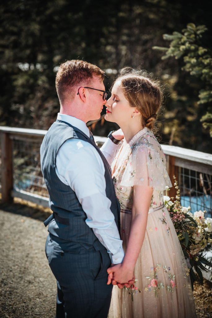 bride and groom kissing on mendenhall glacier trail