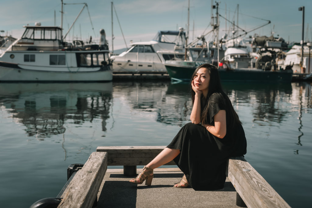Personal branding photoshoot of Rizza Marvel of Z Squared studio sitting on boat dock. 