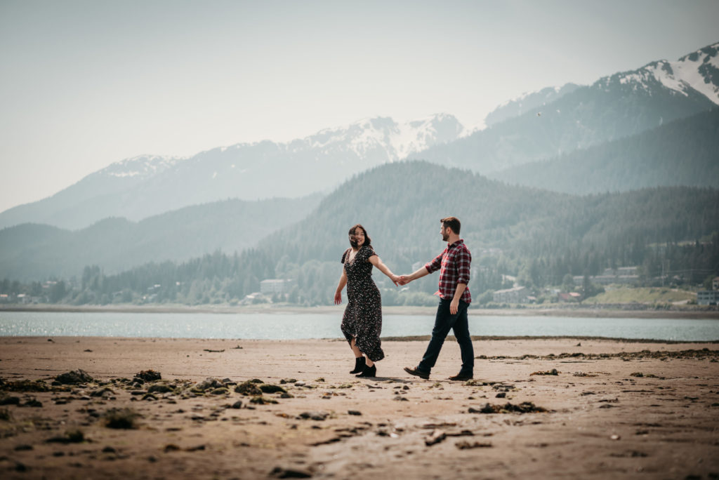 couple walking beach in juneau alaska