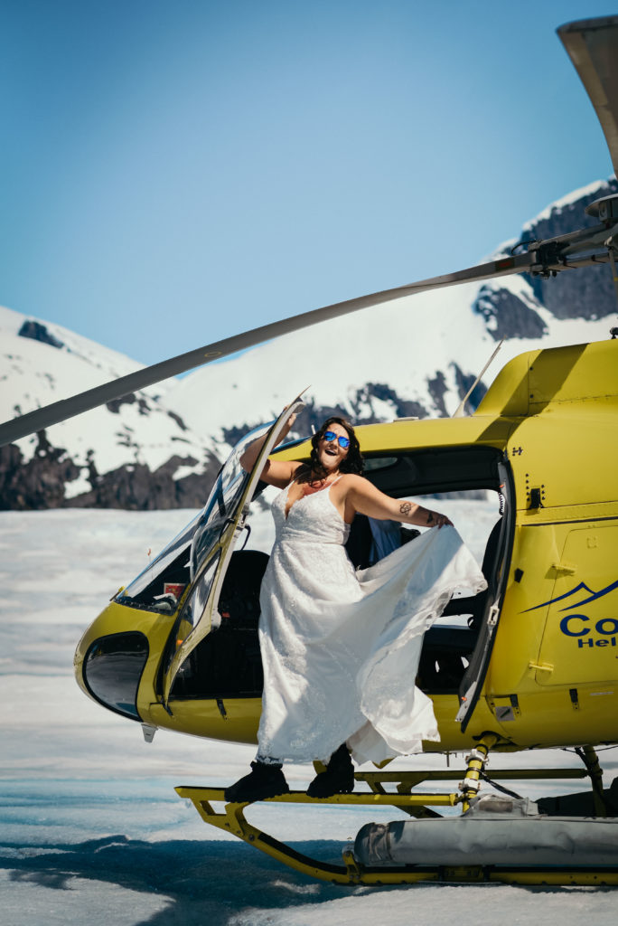 bride exiting helicopter on glacier