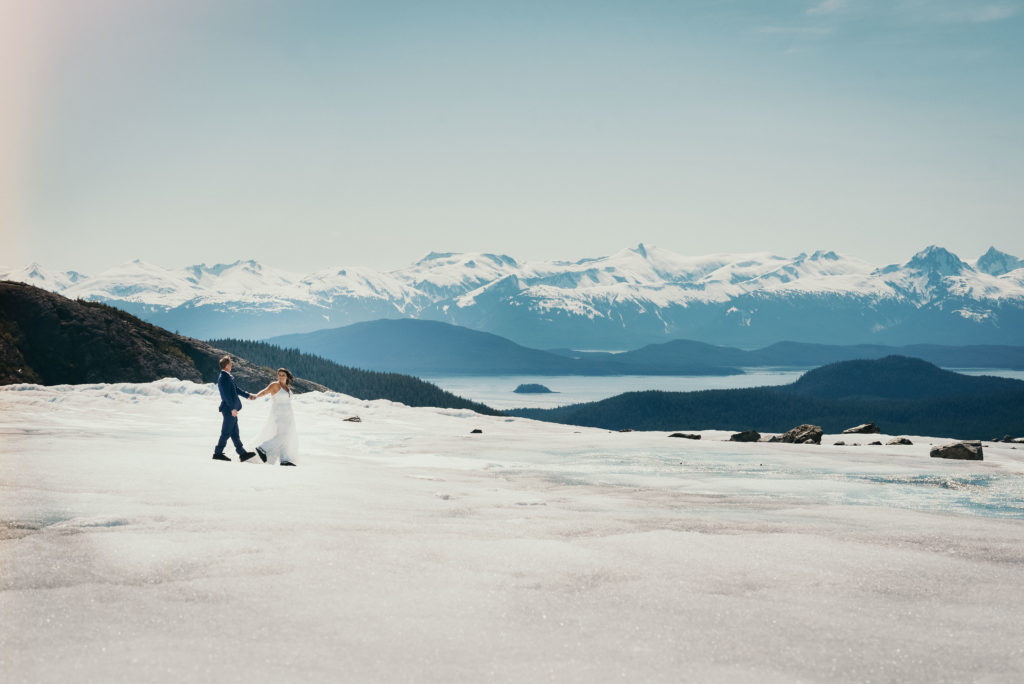 bride and groom walking on glacier with gorgeous background