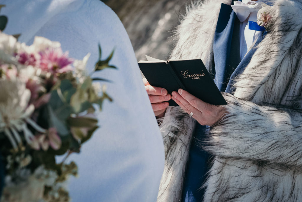 grooms vow book during alaska glacier wedding