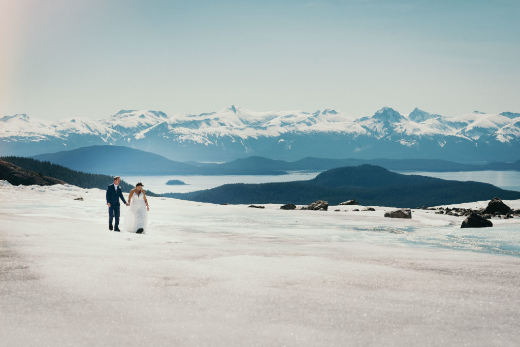 bride and groom walking on herbert glacier with beautiful background