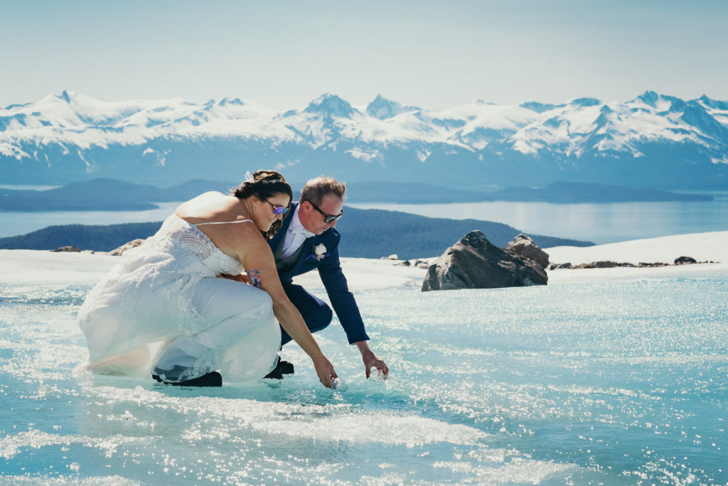 bride and groom collecting water from glacier stream