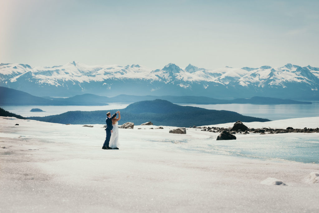bride and groom dancing on glacier with gorgeous background