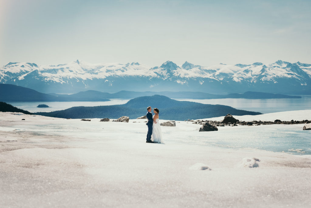 bride and groom hugging on herbert glacier with epic background