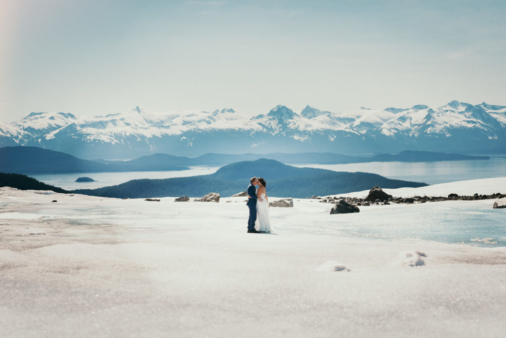 bride and groom hugging on juneau glacier with gorgeous background
