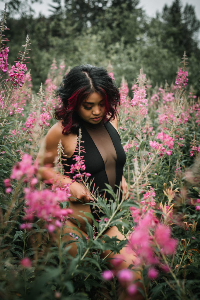 woman in black lingerie posing in the wildflowers