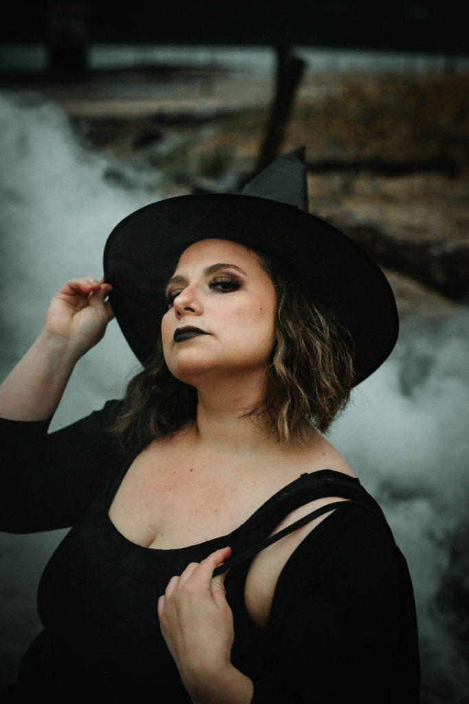 woman dressed as witch with smoke bombs