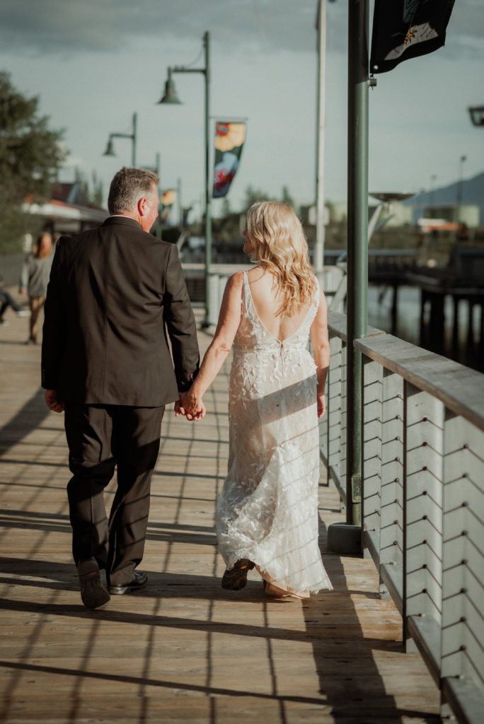 bride and groom walking docks of juneau alaska after elopement