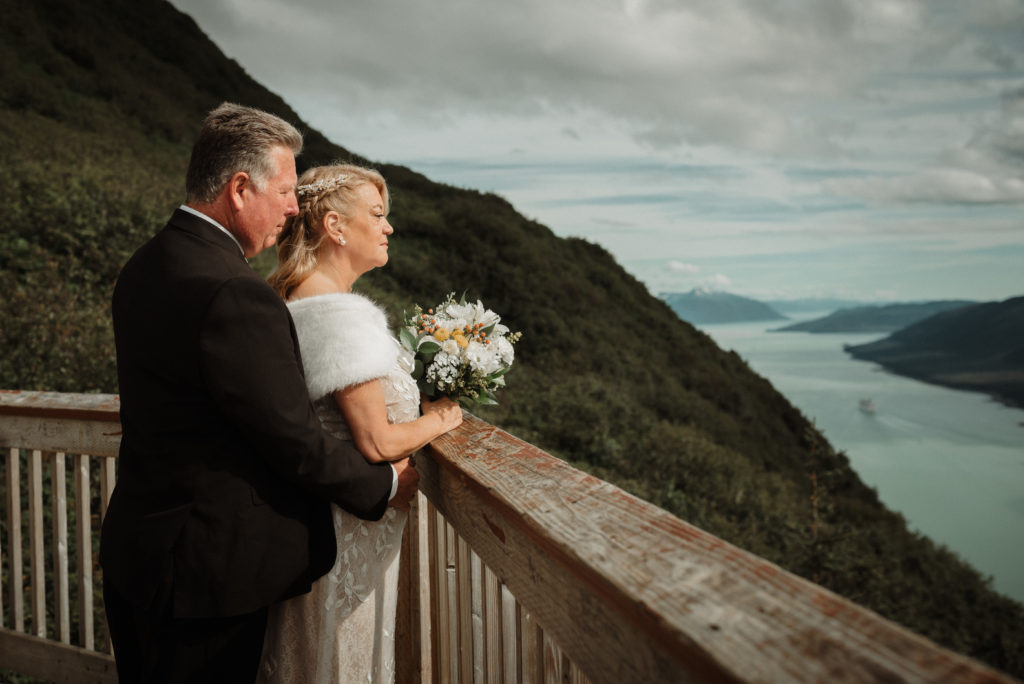 bride and groom enjoy views of the gastineau channel after eloping on mount roberts