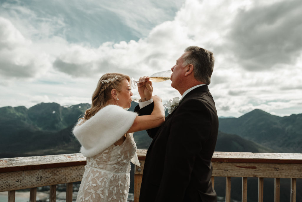 bride and groom champagne toast on mount roberts in juneau alaska