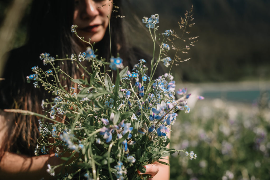 personal branding photograph of woman holding bouquet of wildflowers in Alaska