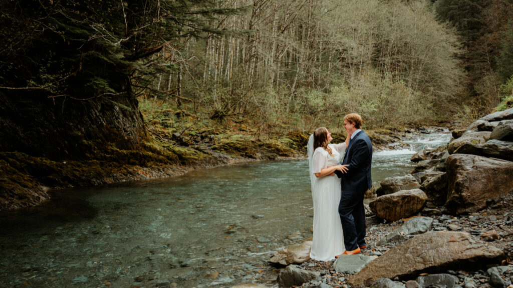 bride and groom at cope park in juneau alaska with blue water gold creek