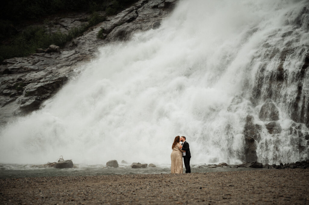 couple in front of nugget falls in juneau alaska