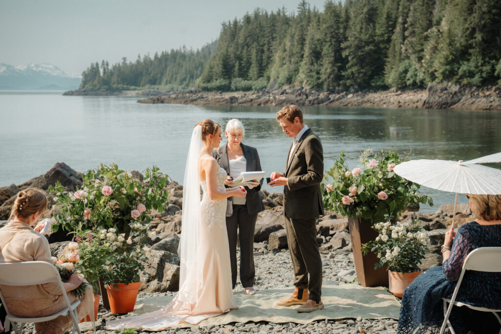A whimsical beach wedding at Ernest Gruening State Park in Juneau, Alaska, with white parasols flower pots and romantic views